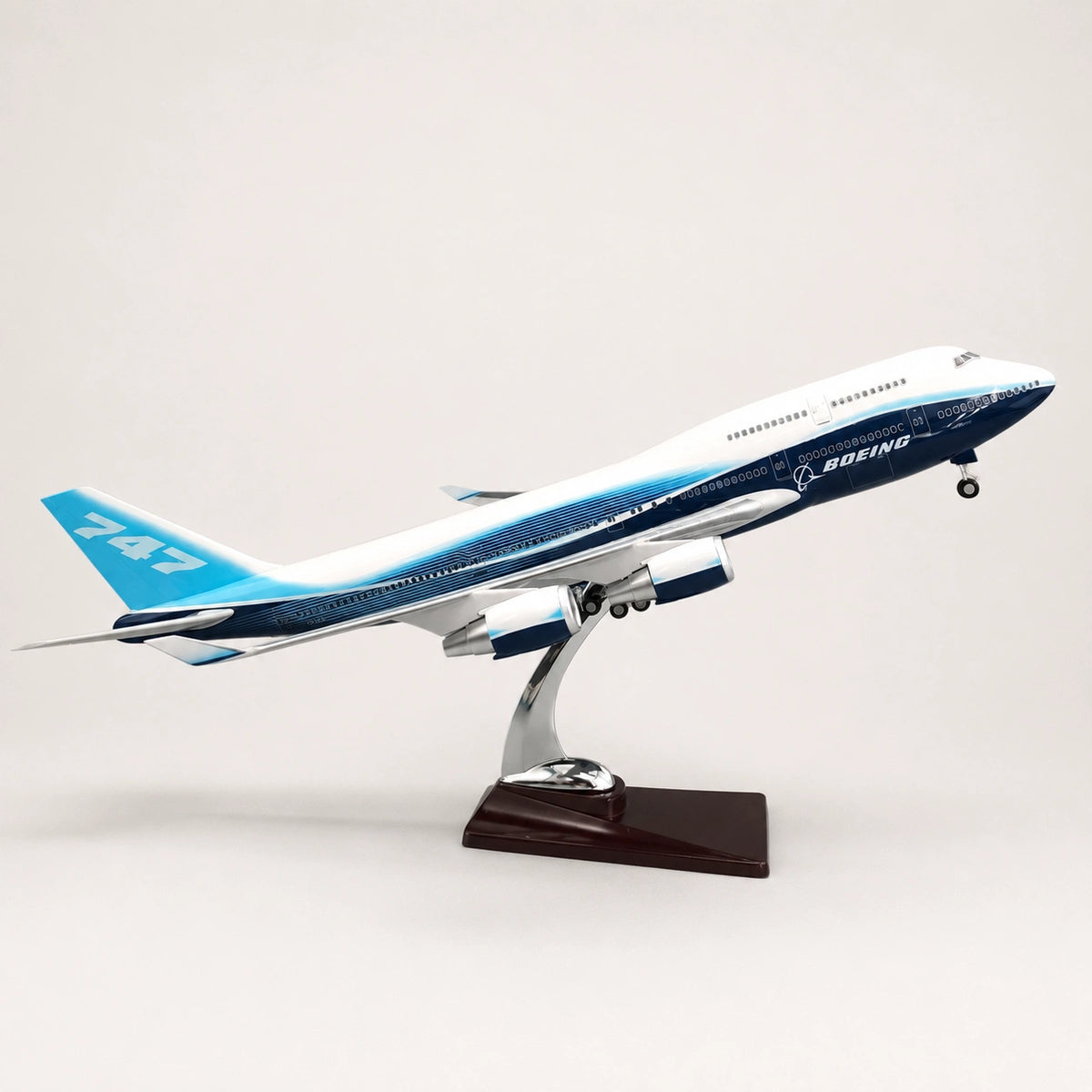 Boeing 747 LED airplane model in takeoff position on a wooden display stand.